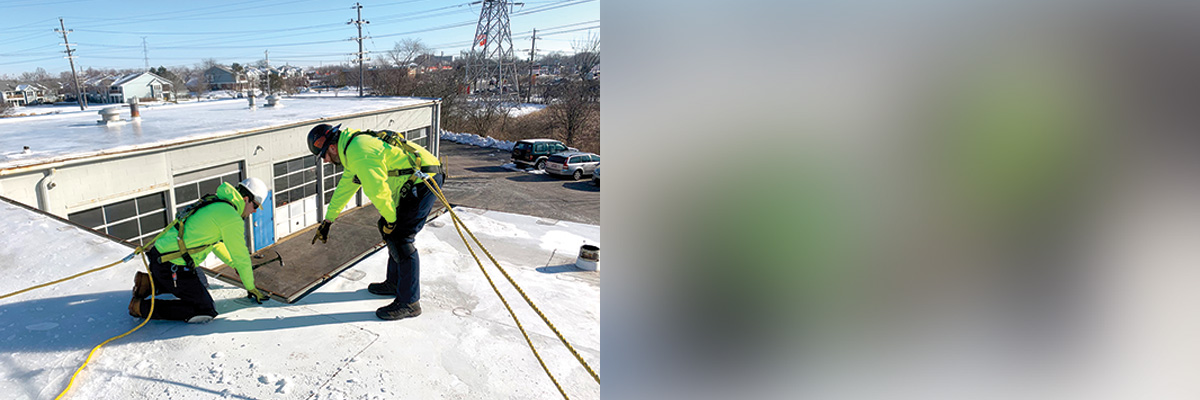 Workers in safety gear repairing roof