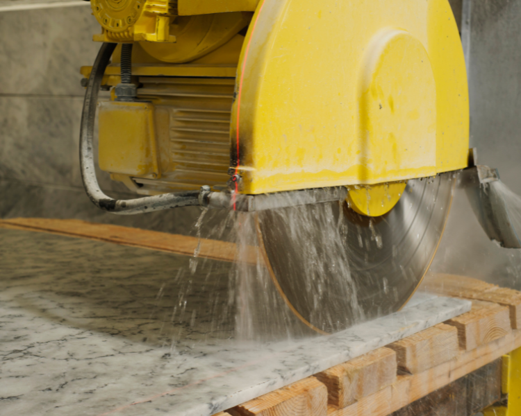 A wet tile saw cutting into a granite tile