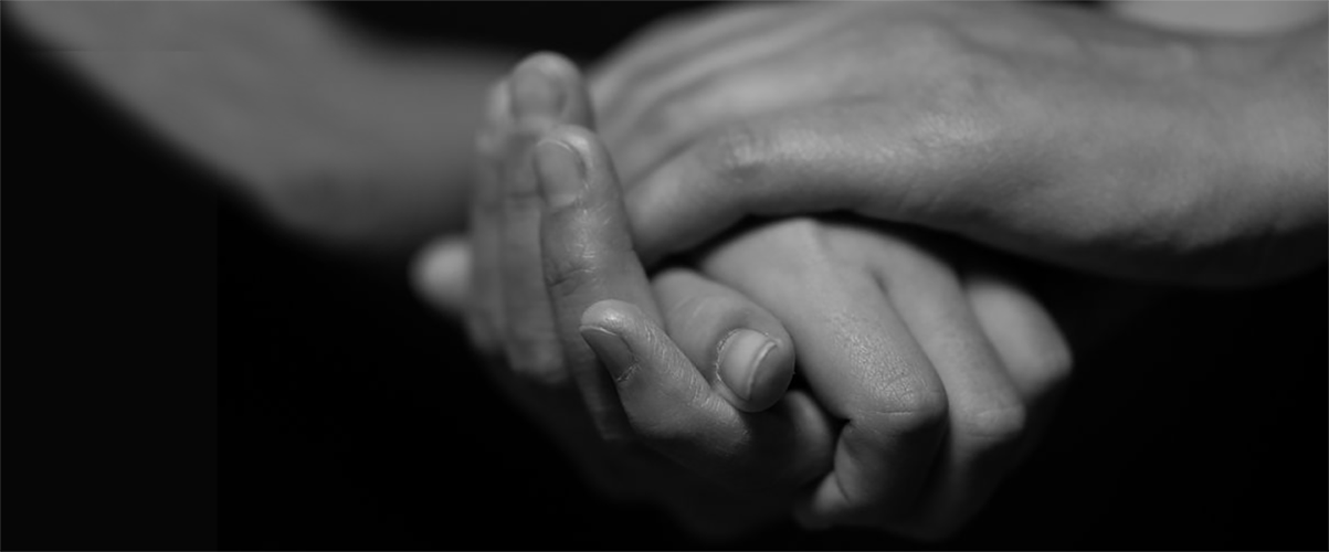 Workers Memorial - close up of hands in dark background