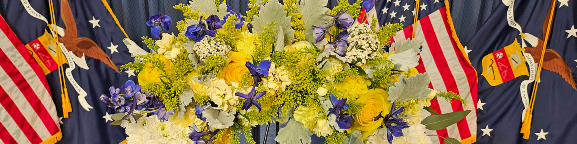 Flower wreath with flags of the United States of America behind it
