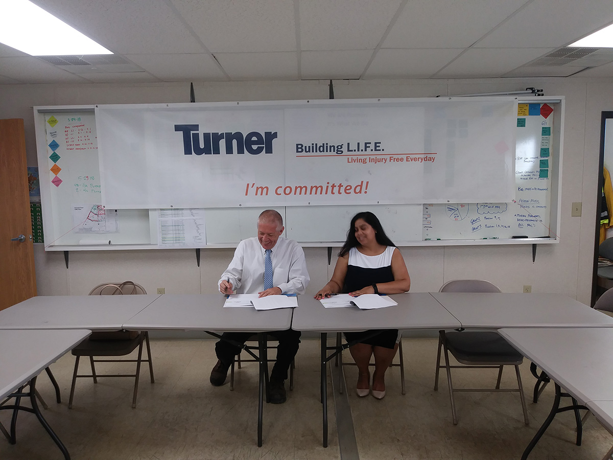 Chris Jahrling, VP, General Manager - Federal, Turner Construction Company and Nadira Janack, Area Director, Baltimore Washington DC Area Office, US DOL – OSHA, sign the Partnership agreement.