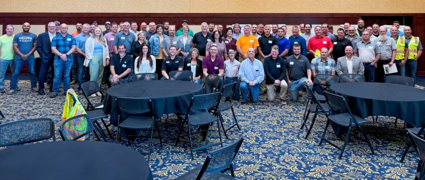 In a hotel conference room, a very large group of Partnership signatories, supporting company and labor representatives, and the ceremony attendees assembled for a group photo after the signing ceremony