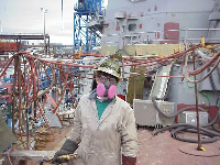 Figure 7: Burner wearing respirator, tinted face shield and leather gloves.