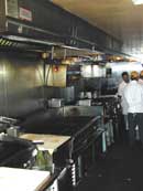 Image of a restaurant grill with workers in the background.