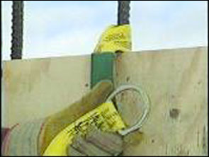 Figure 15 - A worker placing a strap on anchor over rebar. For problems with accessibility in using figures and illustrations, please contact the DOC at 202-693-2020.
