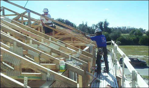 Figure 2 - Workers using an exterior bracket scaffold to install roof trusses. For problems with accessibility in using figures and illustrations, please contact the DOC at 202-693-2020.