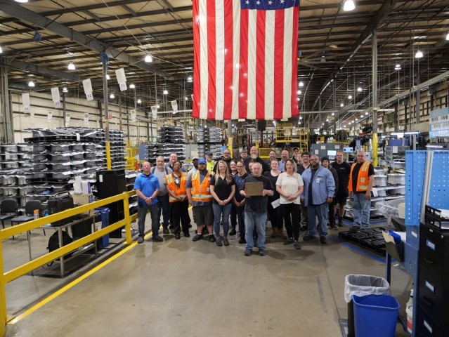 Company representatives standing with Gold award.
