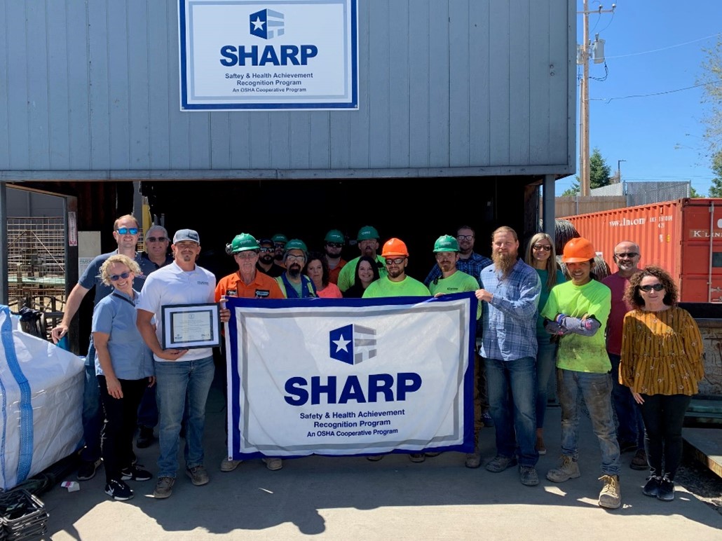 Nucor Harris employees holding up SHARP flag.