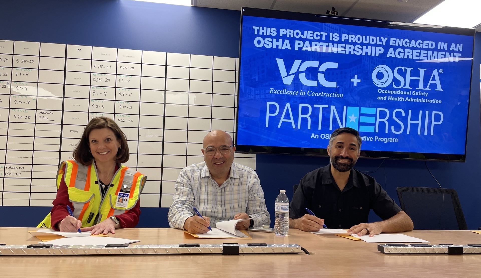 Karena Lorek, Area Director, Kansas City Area Office, US DOL-OSHA; Wayne Alley, Executive Vice President, VCC, LLC and Eli Pano, Project Compliance and Risk Manager, VCC, LLC sign the Partnership agreement.