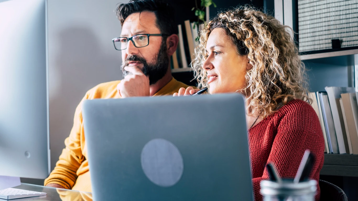 Two people looking at a computer monitor