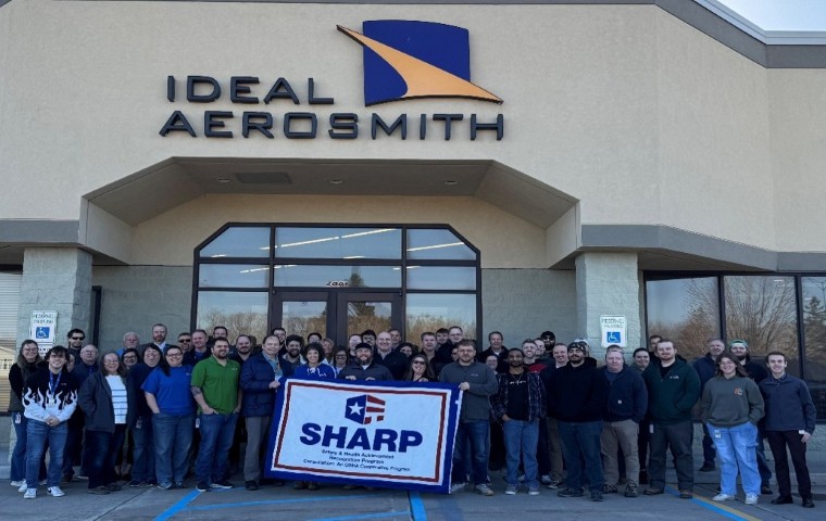 Employees stand with SHARP flag