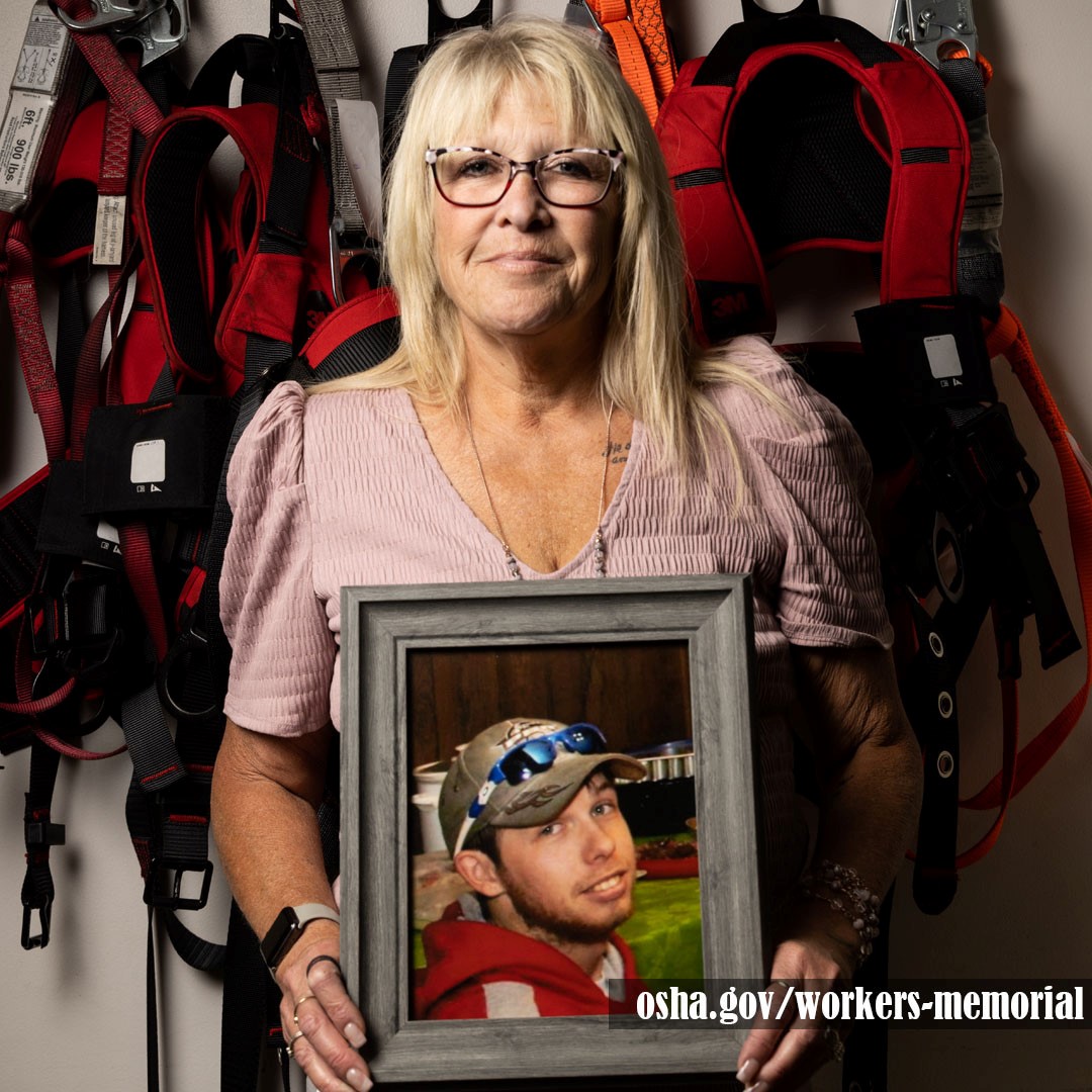 Individual holding up photo of a fallen worker.