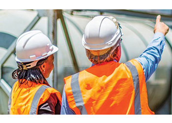 Workers in hardhats and high-viz vests on work site