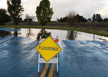 Flooded road with flood warning sign