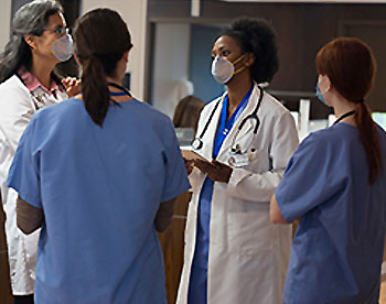 Hospital workers wearing masks during discussion