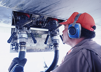 Worker wearing protective ear muffs