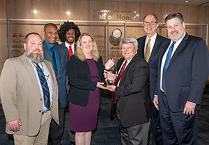 Acting OSHA Assistant Secretary Loren Sweatt (center left) accepts the award from NCCCO president J. Kerry Hulse, surrounded by OSHA and NCCCO