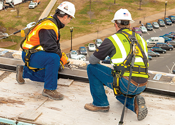 Workers wearing fall prevention gear on roof