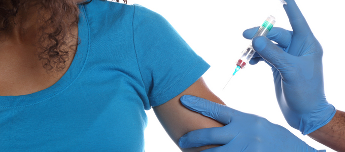 Nurse administering vaccine to patient