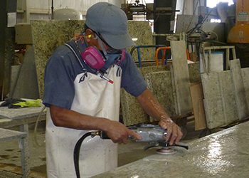 Worker sanding silica countertop