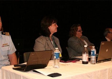 Agency presenters watch a presentation from PHMSA on its experience with performance-based regulations in the oil and gas industry