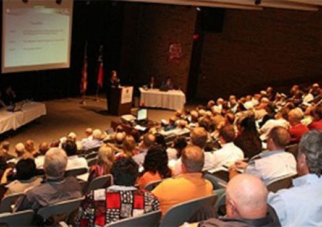 Public stakeholders watch an agency presentation on performance-based regulatory models.