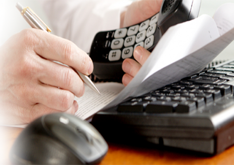 Worker using a phone and writing on paper