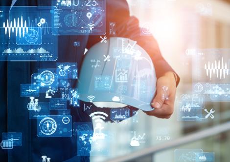 Injury Tracking Application (ITA) - iStock image person holding hard hat with hologram graphs overlayed in foreground